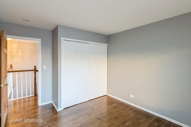 unfurnished bedroom with hardwood / wood-style flooring and a closet