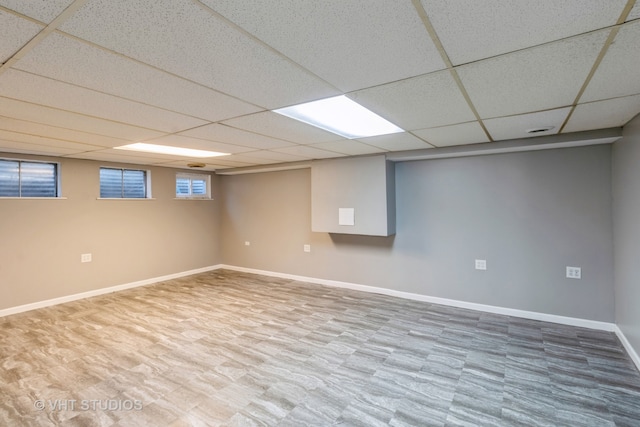 basement featuring a paneled ceiling and hardwood / wood-style floors