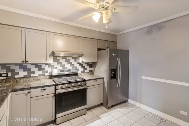 kitchen featuring stainless steel appliances, dark stone counters, backsplash, light tile patterned floors, and exhaust hood