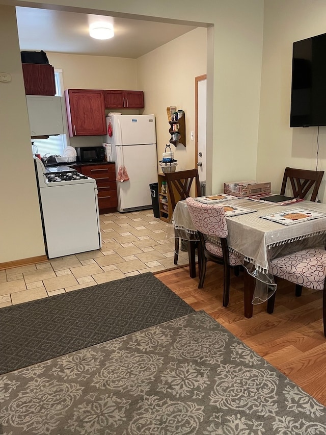 kitchen with white appliances and light hardwood / wood-style floors