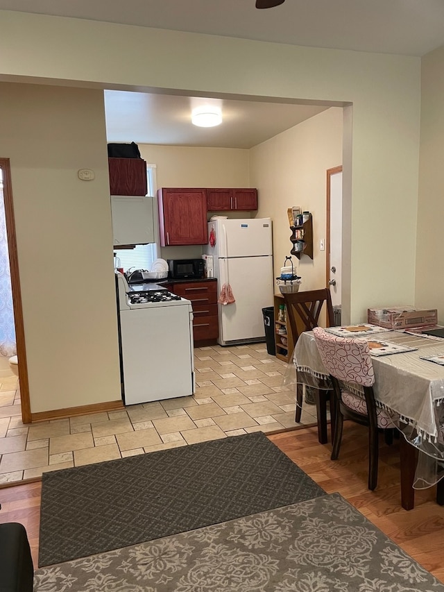 kitchen with white appliances and light hardwood / wood-style flooring