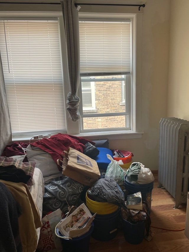 bedroom featuring radiator heating unit and wood-type flooring