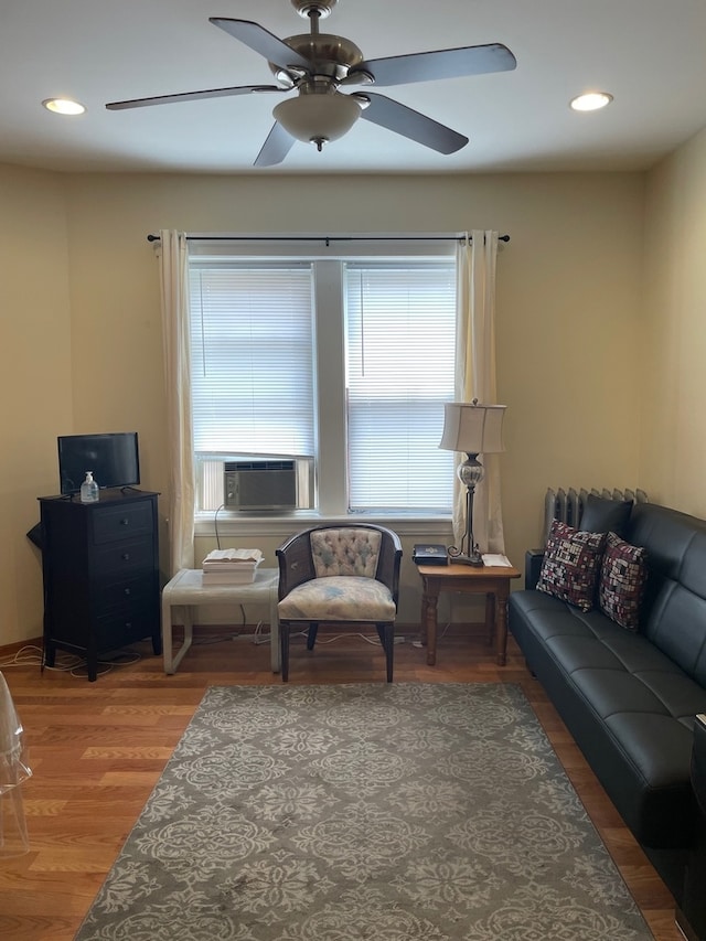 living room with cooling unit, hardwood / wood-style flooring, and ceiling fan