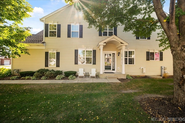 colonial inspired home with a patio and a front yard