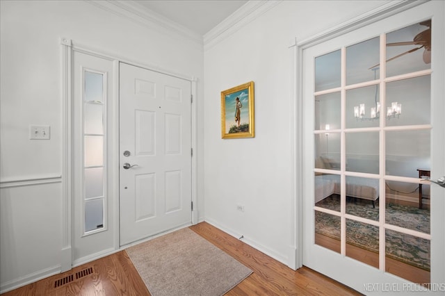 entryway featuring crown molding and hardwood / wood-style floors