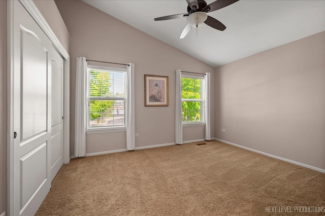 carpeted empty room featuring ceiling fan and vaulted ceiling