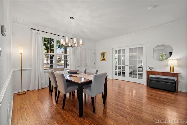 dining space featuring crown molding, french doors, and wood-type flooring