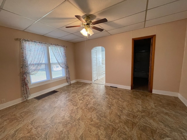 empty room featuring a paneled ceiling and ceiling fan