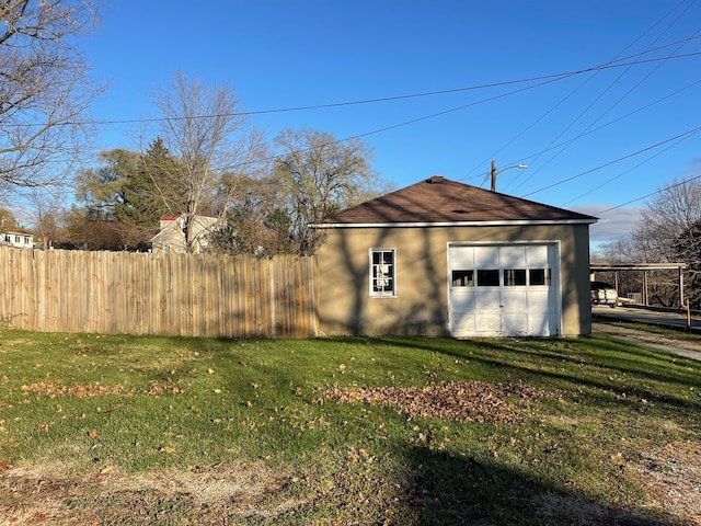 view of side of property featuring a lawn, an outbuilding, and a garage