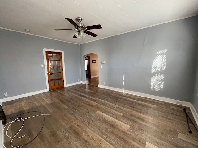 empty room with ceiling fan, dark hardwood / wood-style flooring, and ornamental molding