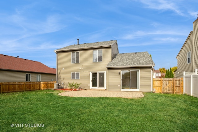 rear view of house with a lawn, central AC, and a patio