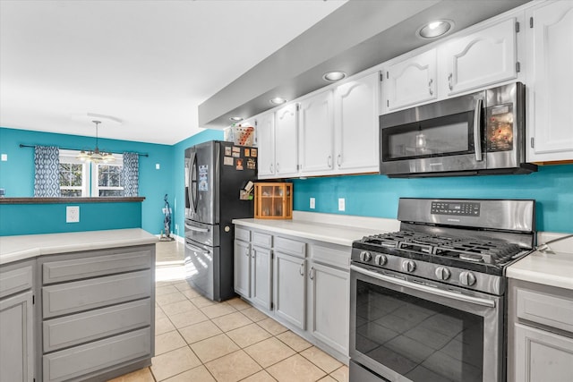 kitchen featuring white cabinetry, stainless steel appliances, light tile patterned floors, and pendant lighting