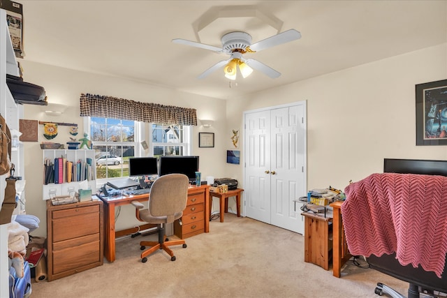 carpeted office space featuring ceiling fan