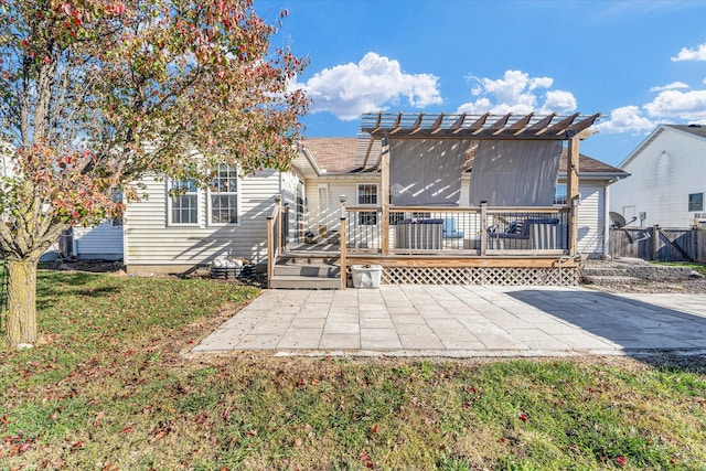 rear view of property featuring a patio, a pergola, a yard, and a wooden deck