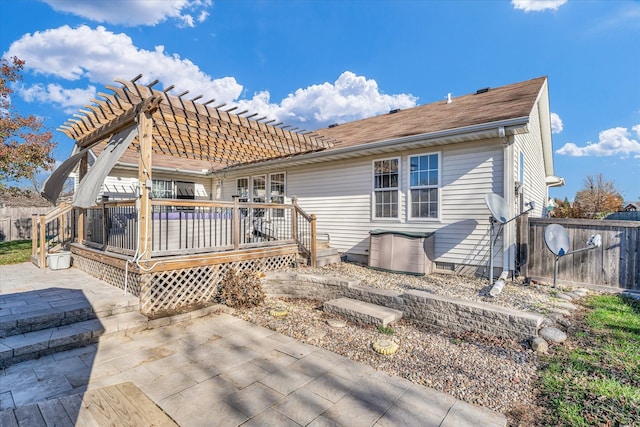 back of house with a wooden deck, a pergola, and a patio