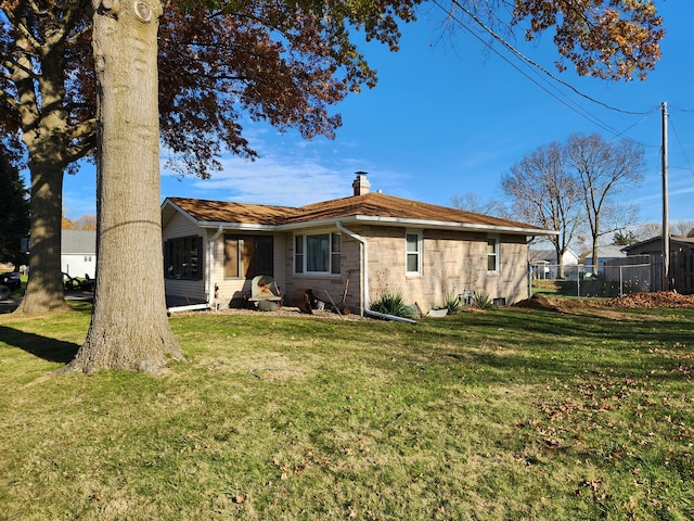 rear view of house featuring a lawn