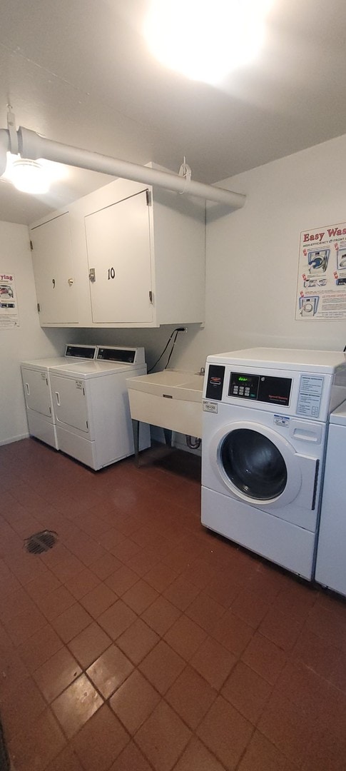 laundry area with separate washer and dryer, cabinets, and sink