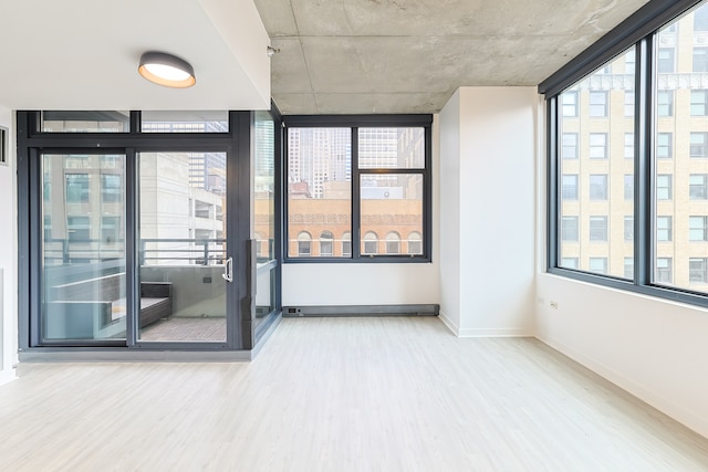 empty room featuring expansive windows, plenty of natural light, and wood-type flooring