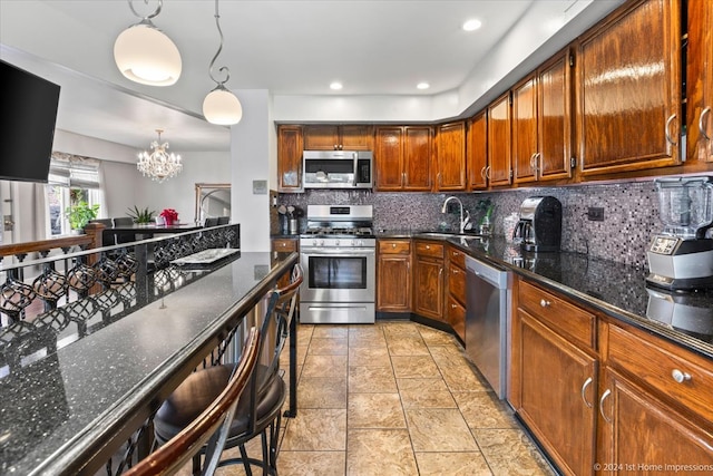 kitchen with stainless steel appliances, tasteful backsplash, dark stone counters, a notable chandelier, and pendant lighting