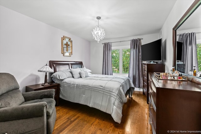 bedroom featuring dark wood-type flooring and an inviting chandelier