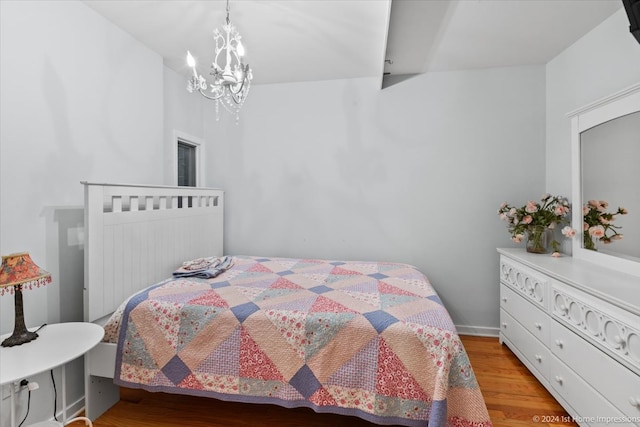 bedroom featuring an inviting chandelier and light hardwood / wood-style flooring