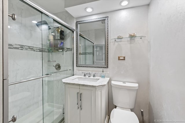 bathroom featuring an enclosed shower, vanity, and toilet