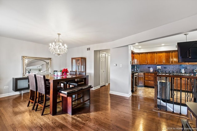 dining room featuring dark wood-type flooring and an inviting chandelier