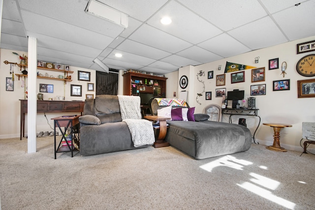 carpeted living room featuring a drop ceiling