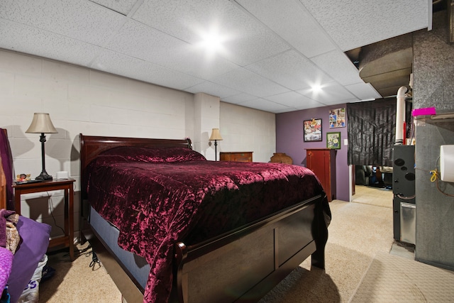 carpeted bedroom featuring a drop ceiling