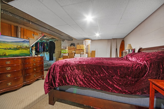 carpeted bedroom featuring a drop ceiling