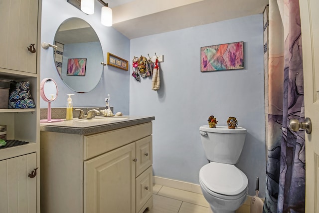 bathroom with toilet, vanity, and tile patterned flooring