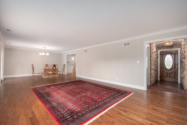 entrance foyer featuring crown molding, dark hardwood / wood-style flooring, and an inviting chandelier