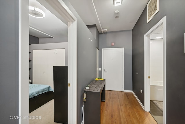 hallway with light hardwood / wood-style floors