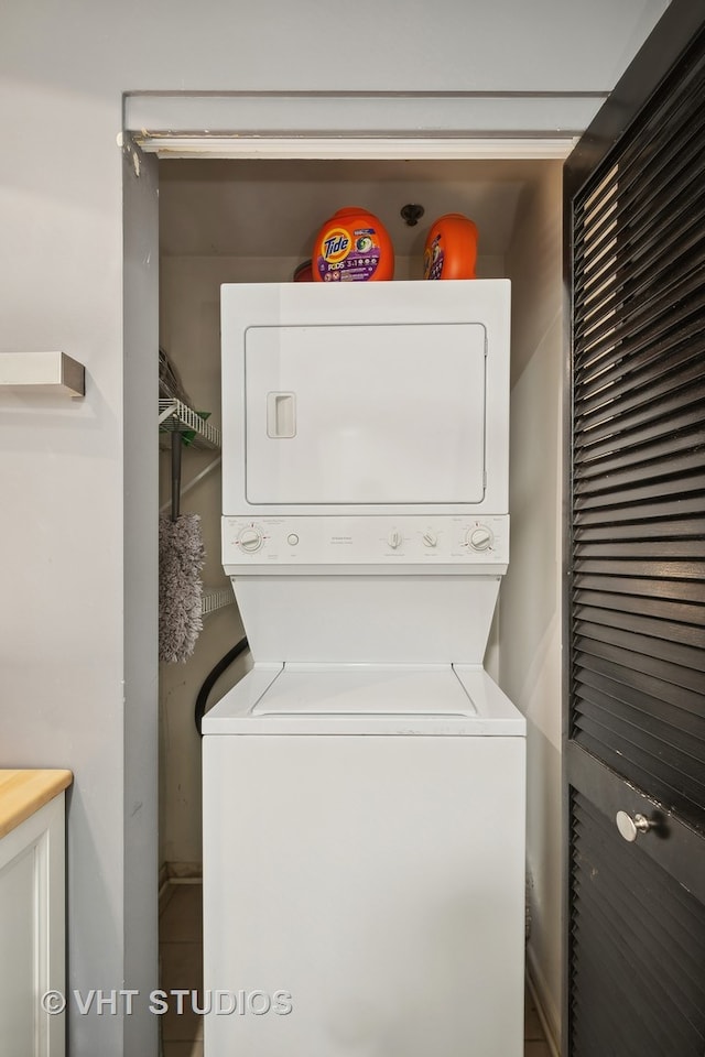 laundry room featuring stacked washer / drying machine