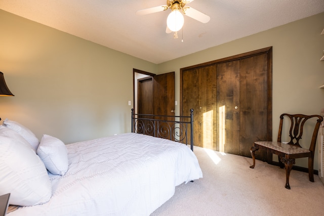 carpeted bedroom with ceiling fan and a closet