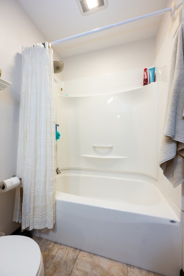 bathroom with shower / bath combination with curtain and toilet