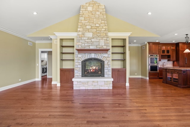 unfurnished living room featuring built in shelves, crown molding, dark wood-type flooring, and lofted ceiling