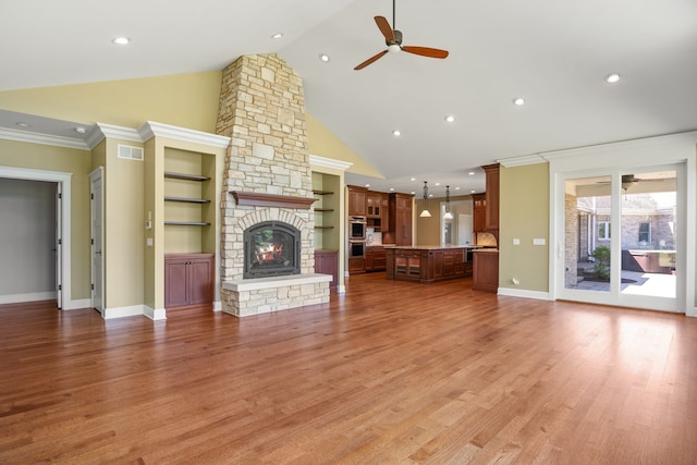 unfurnished living room featuring a fireplace, crown molding, high vaulted ceiling, hardwood / wood-style flooring, and ceiling fan