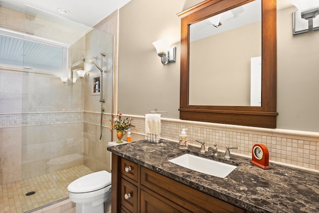 bathroom featuring toilet, tasteful backsplash, vanity, and tiled shower