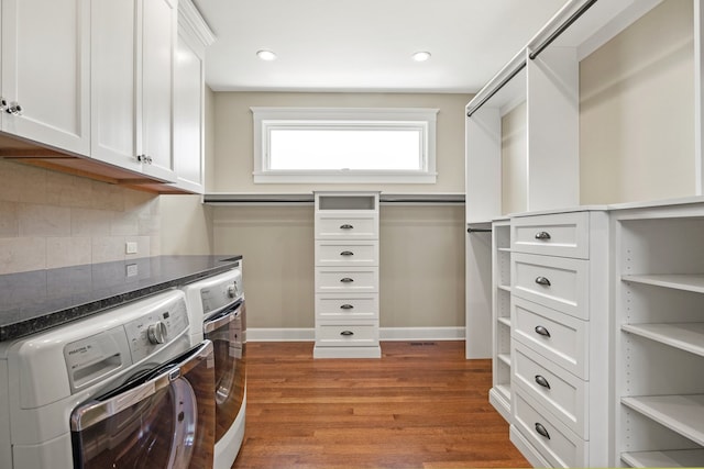 walk in closet featuring washing machine and clothes dryer and dark hardwood / wood-style flooring