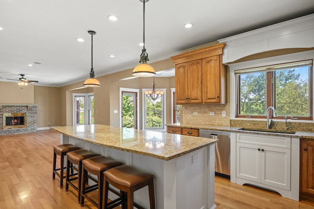 kitchen featuring a kitchen island, stainless steel dishwasher, and light hardwood / wood-style floors