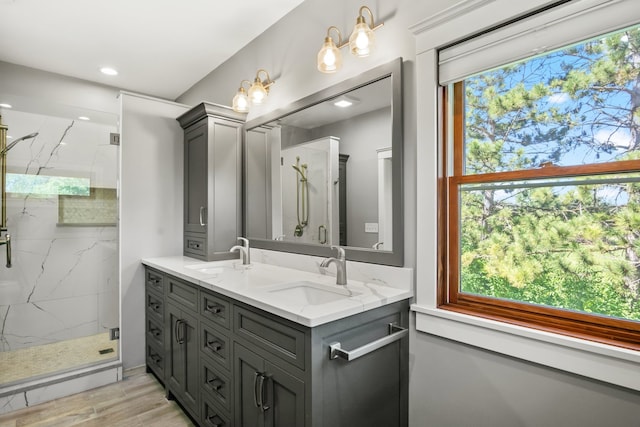 bathroom with wood-type flooring, vanity, and a shower with door