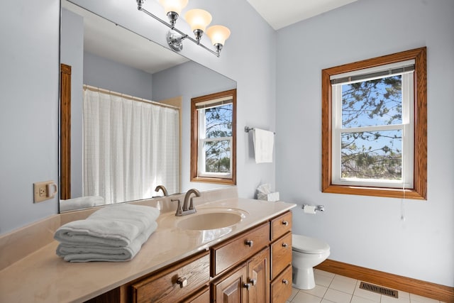 bathroom with toilet, vanity, and tile patterned floors