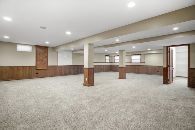 basement featuring wood walls and carpet