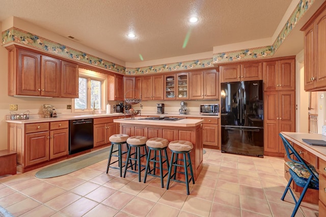 17619 Grandview Dr, Sterling, IL 61081 - kitchen with black appliances, a textured ceiling, a center island, light countertops, and a kitchen breakfast bar