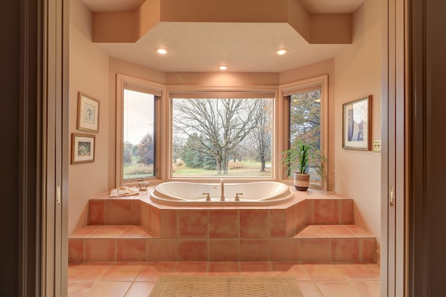 bathroom with tile patterned flooring and tiled bath