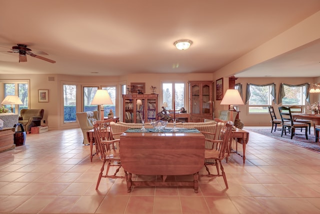 tiled dining space featuring plenty of natural light and ceiling fan