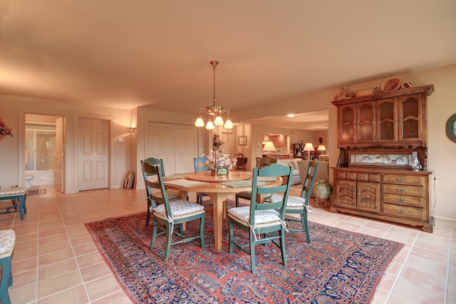 tiled dining area featuring a chandelier