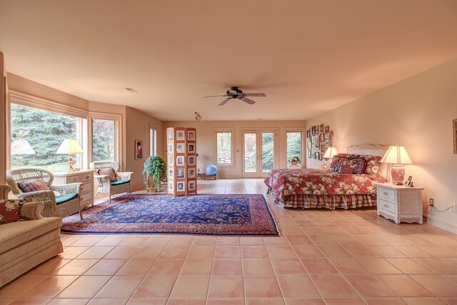 tiled bedroom featuring multiple windows and ceiling fan