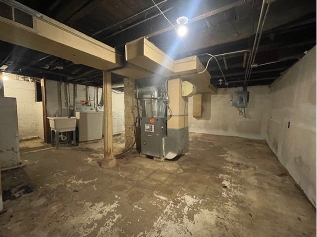 basement featuring washer / dryer, heating unit, and sink